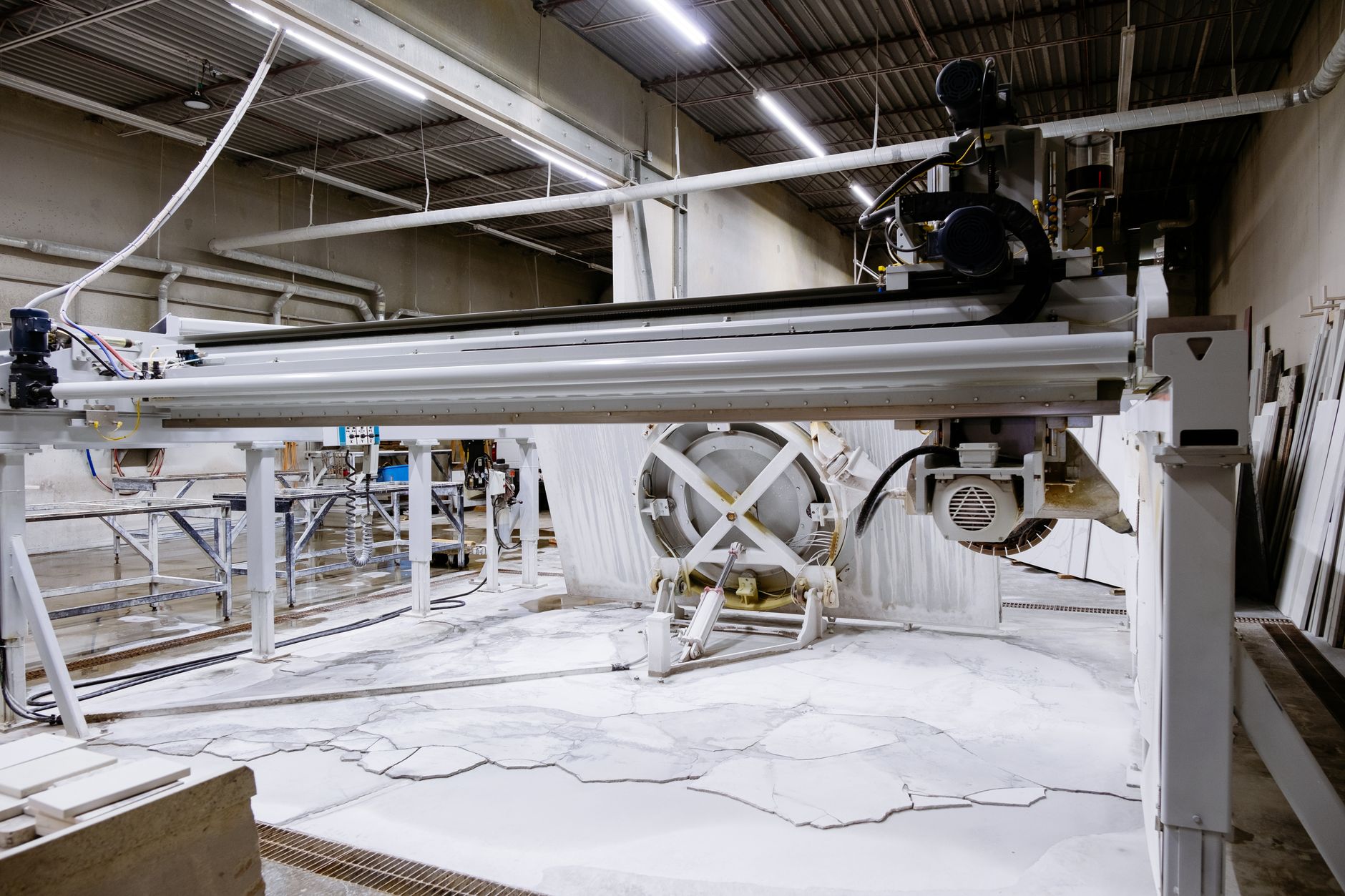 Bridge saw with its overhead gantry and tilting table in a stone fabrication shop