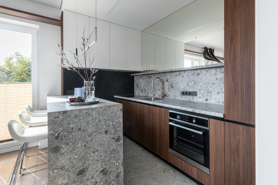 Modern kitchen with dark cabinets, stone countertops, and breakfast bar