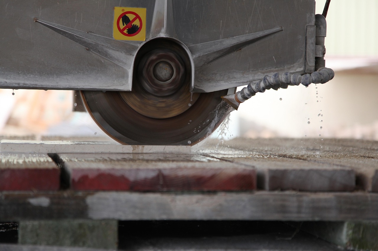 Diamond saw blade cutting stone with water spraying from the coolant nozzle